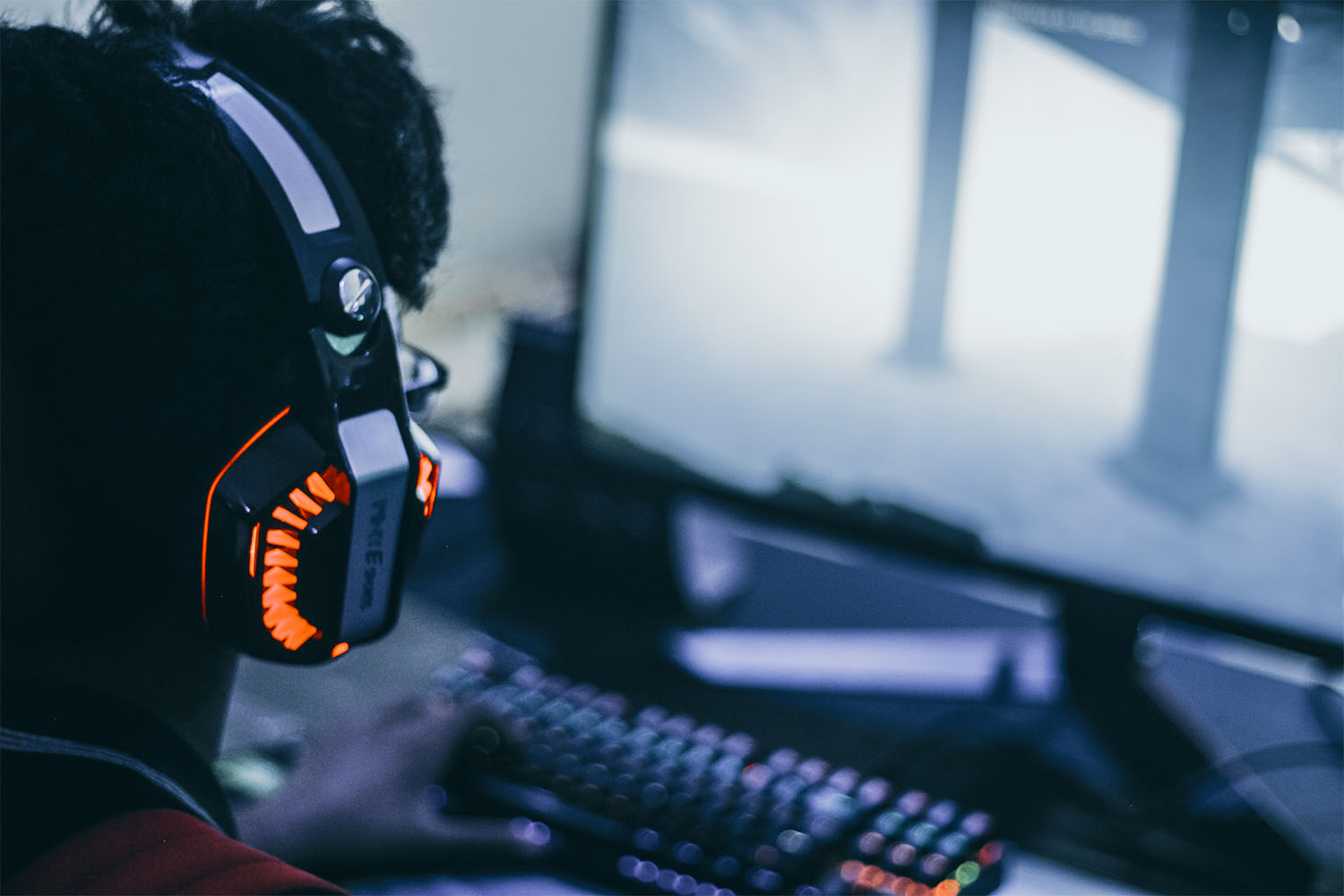 Gamer wearing headset and looking at desktop screen