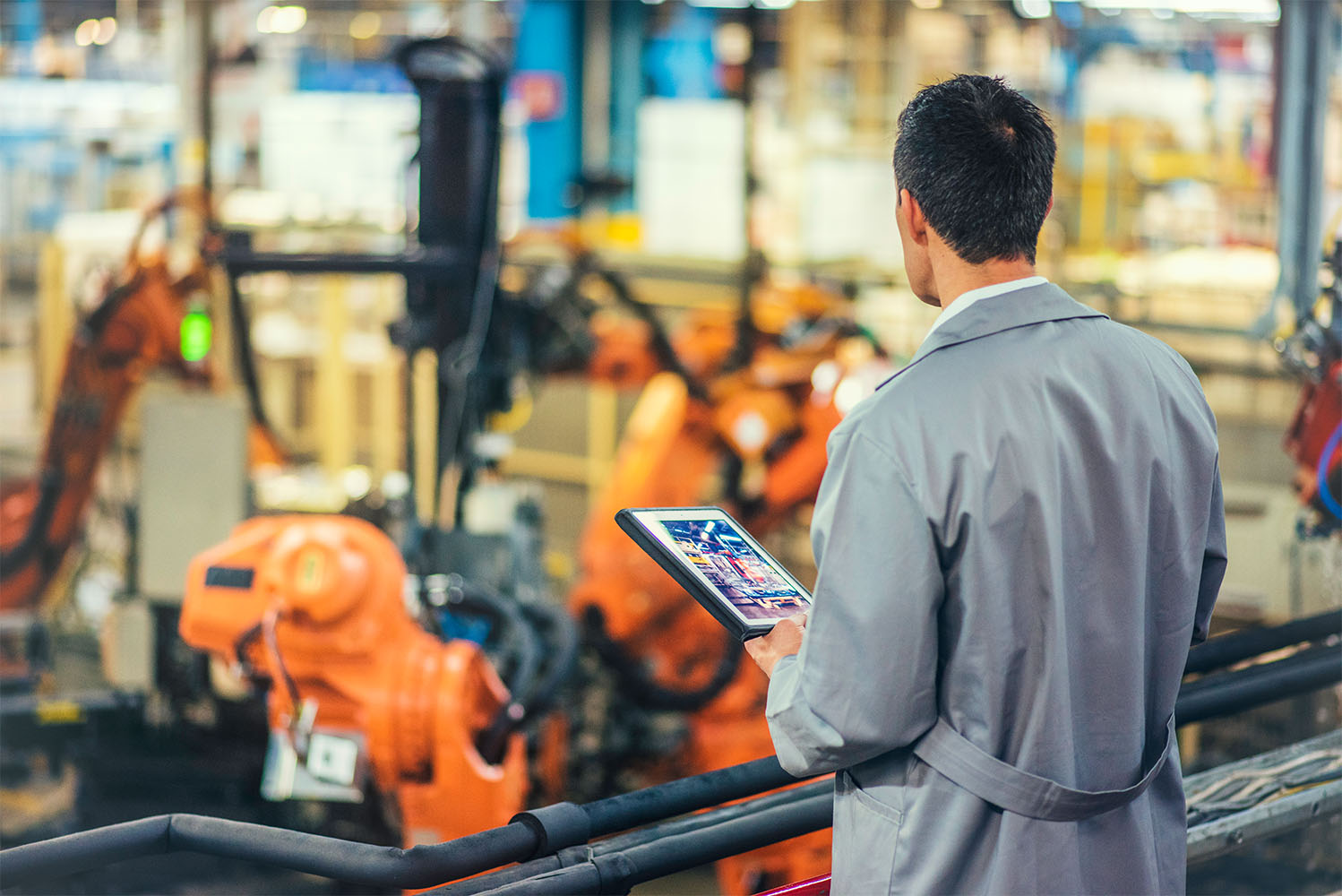 Worker overseeing factory robots