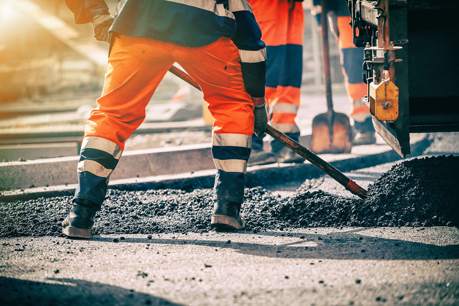 Road worker shovelling gravel