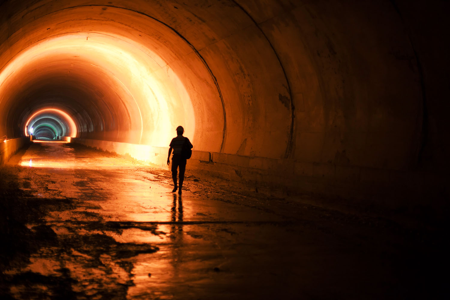 Person walking in a dark tunnel