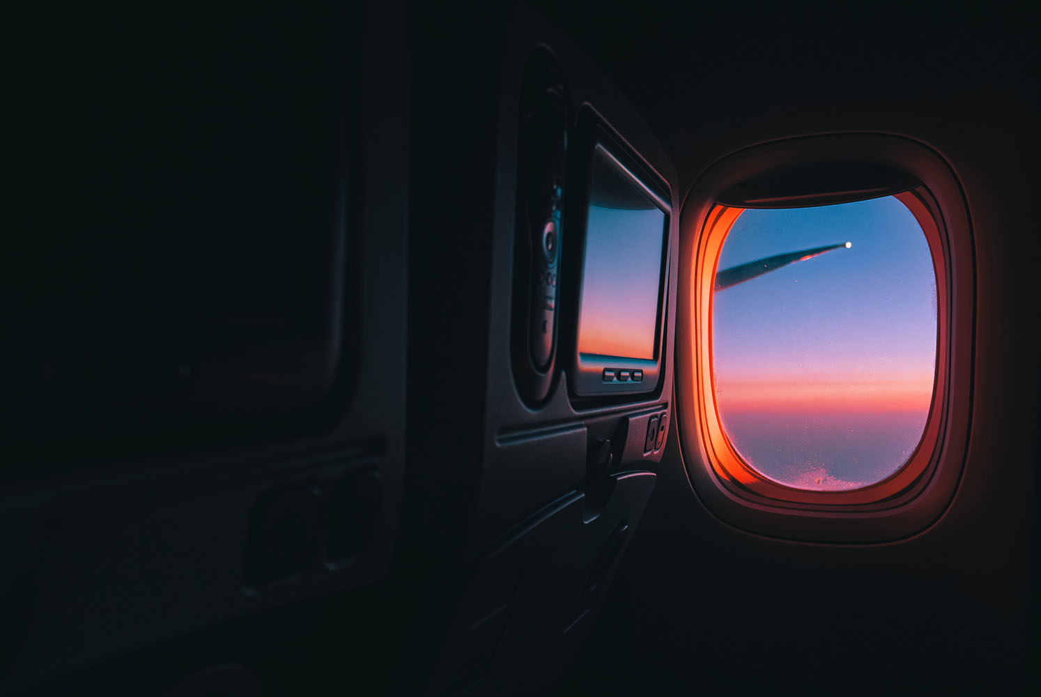 Airplane window with view of sunset