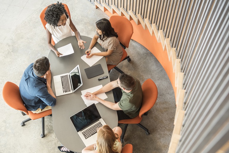 Above view of people in a meeting sitting around a table