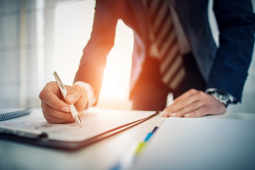 Man in suit signing a document