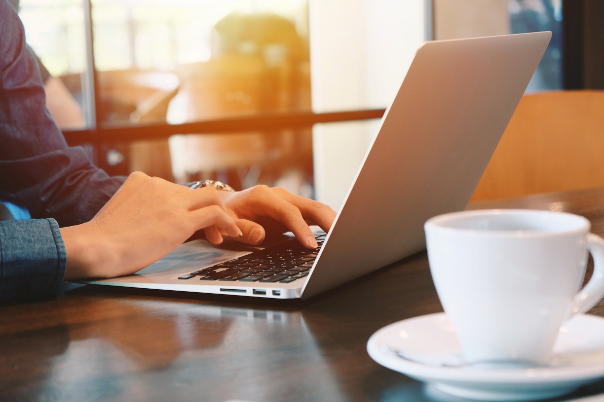 Close up view of a laptop and a cup of coffee