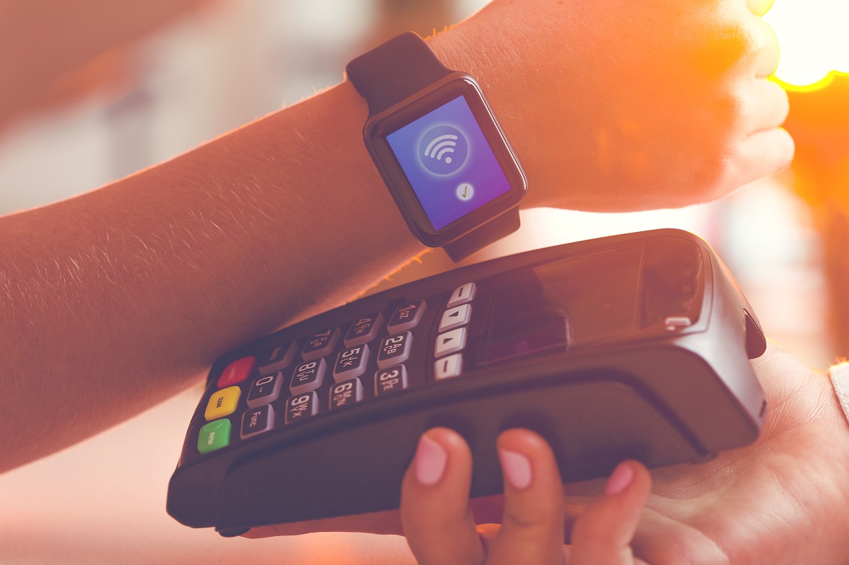 Customer paying with a smartwatch on a payment card reader 