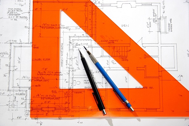 Set square and pencils on top of architecture plans