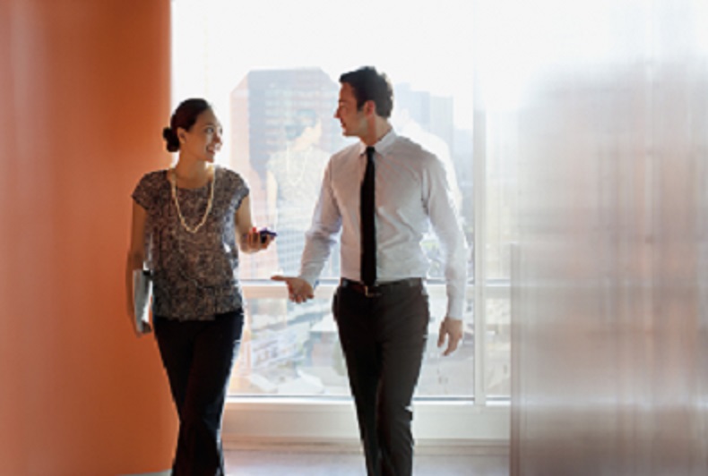 Two people walking and talking in a business setting