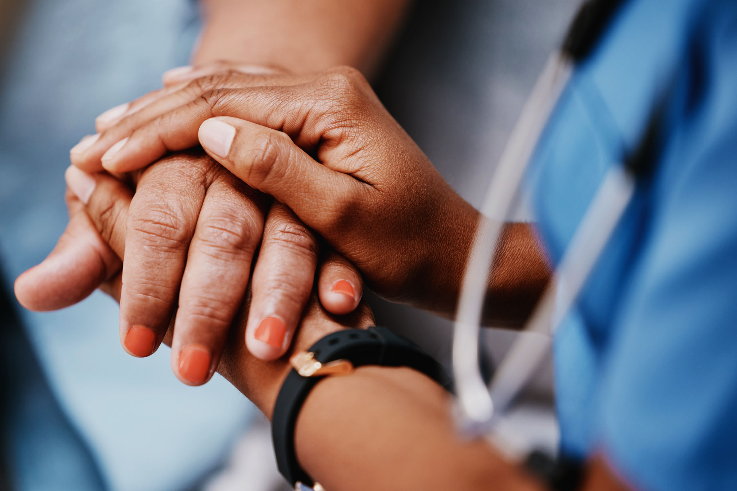 Nurse holding an older lady's hand