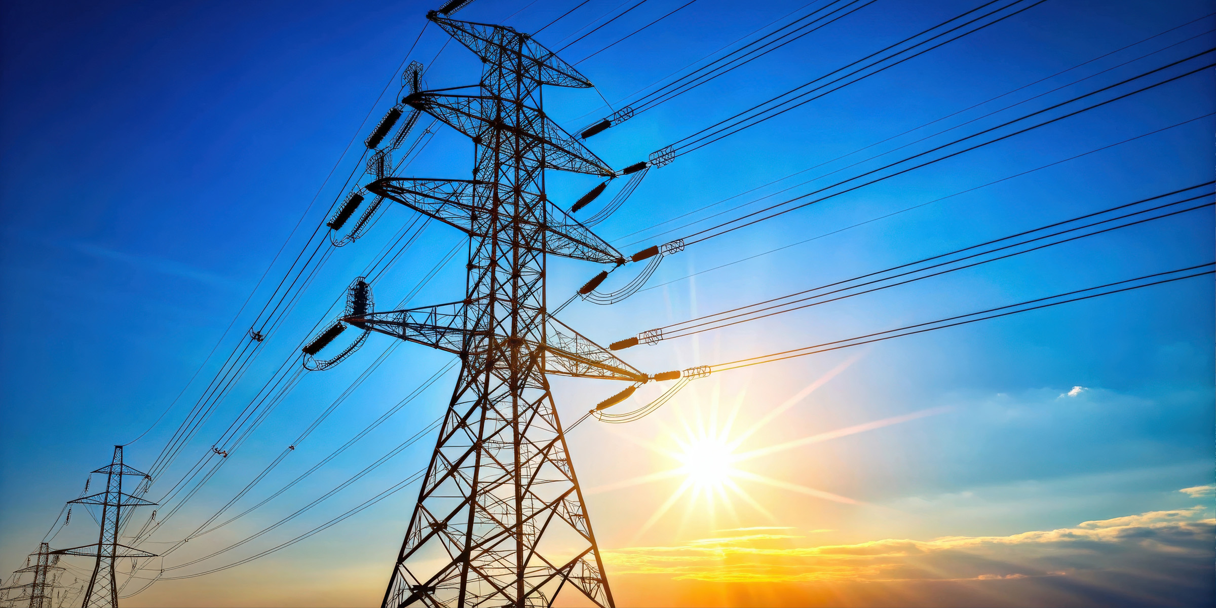 Power line infrastructure with sun and blue sky
