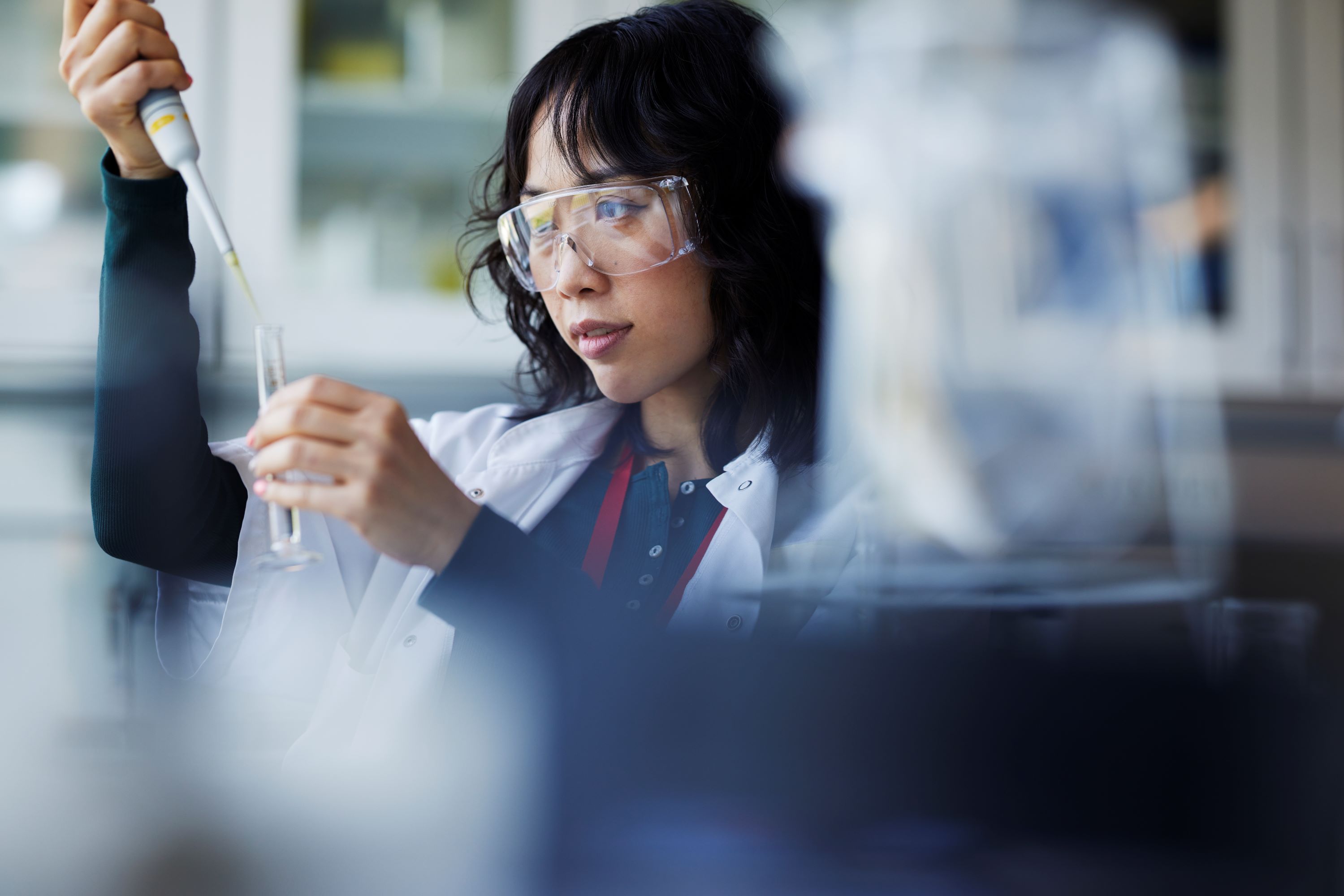 Someone looking at a test tube in a lab