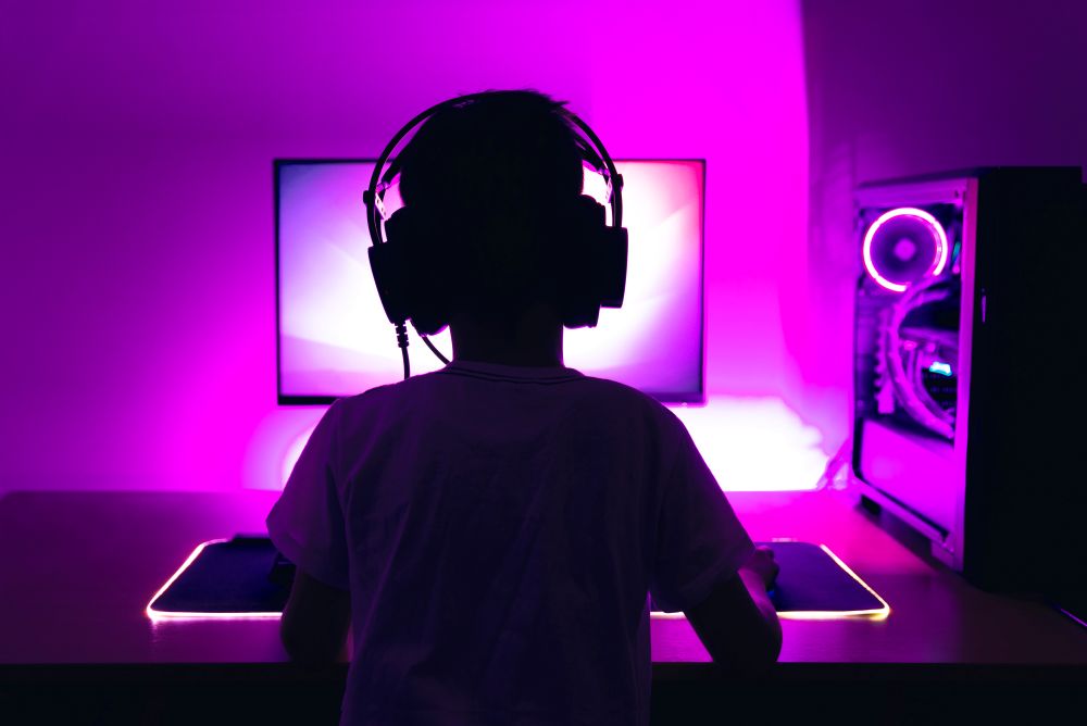 Silhouette of a child playing on a computer